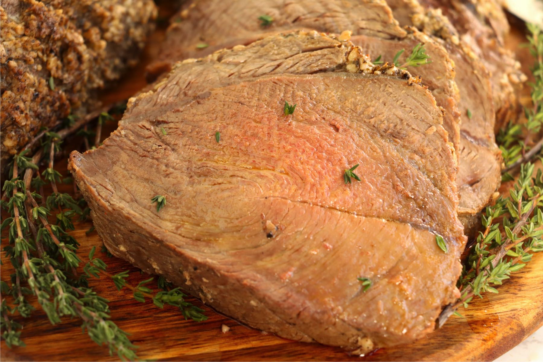 sliced pieces of prime rib on wooden cutting board