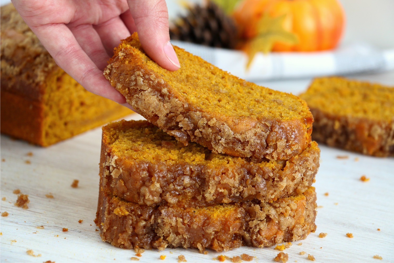 lifting up a piece of pumpkin bread