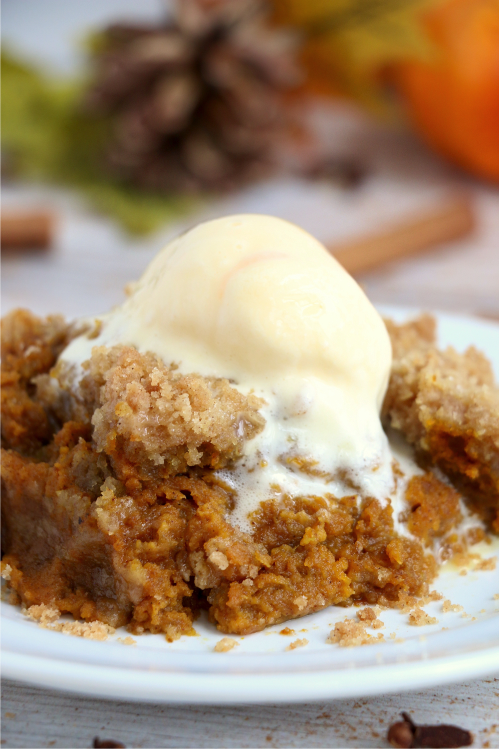 pumpkin crisp on a plate topped with a scoop of ice cream