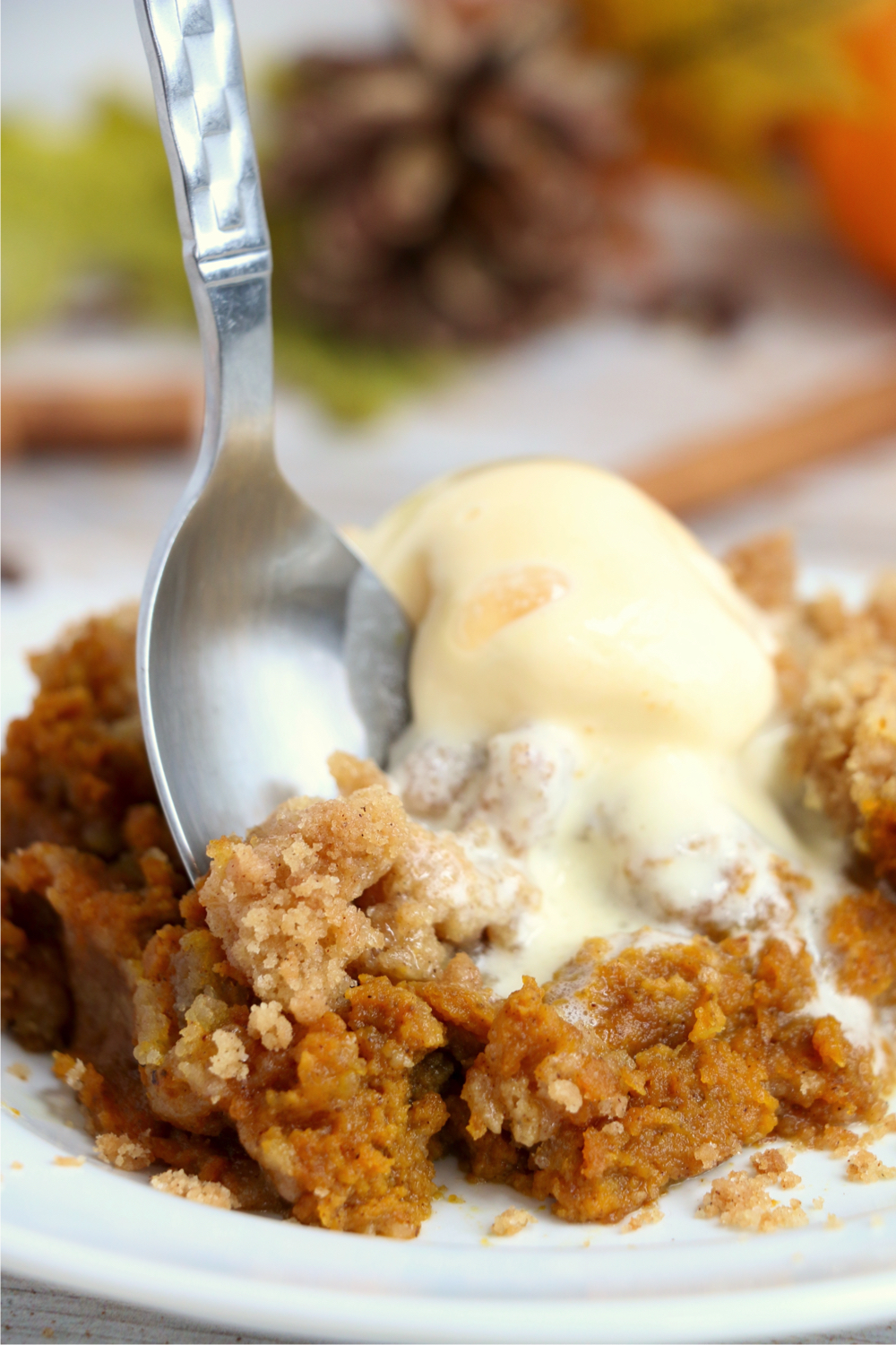 spoon digging into pumpkin crisp with ice cream