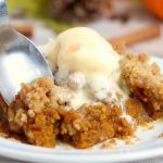spoon digging into pumpkin dessert with ice cream