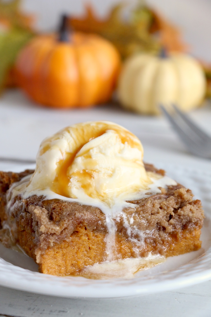 Pumpkin Dump Cake - An easy and delicious pumpkin spice cake topped with vanilla ice cream and caramel drizzle!