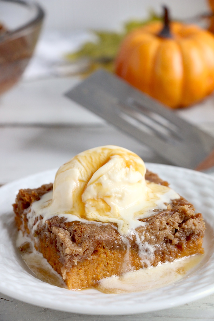Pumpkin Dump Cake - An easy and delicious pumpkin spice cake topped with vanilla ice cream and caramel drizzle!