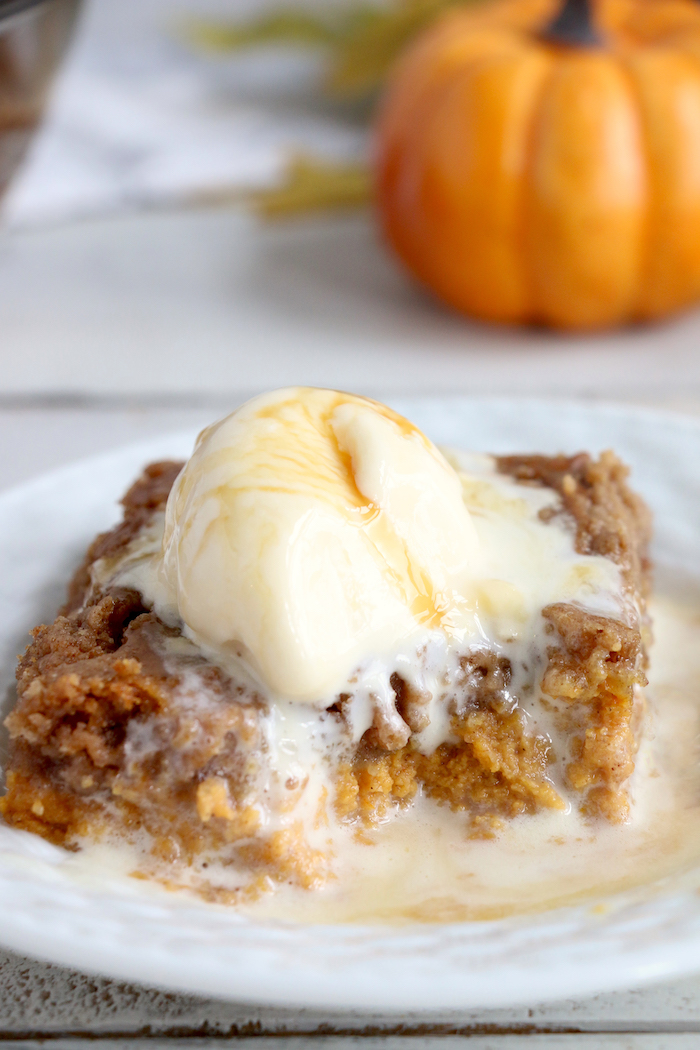 Pumpkin Dump Cake - An easy and delicious pumpkin spice cake topped with vanilla ice cream and caramel drizzle!