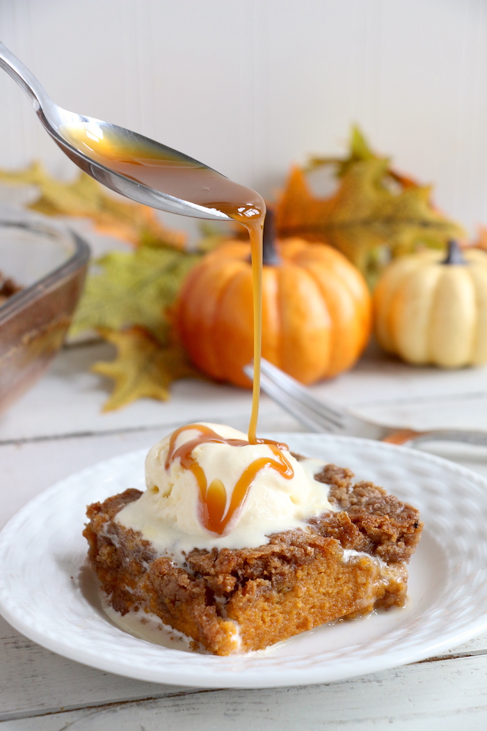 Pumpkin Dump Cake - An easy and delicious pumpkin spice cake topped with vanilla ice cream and caramel drizzle!