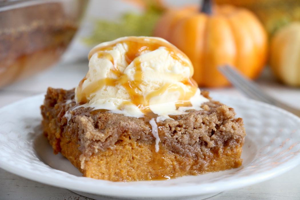 Pumpkin Dump Cake - An easy and delicious pumpkin spice cake topped with vanilla ice cream and caramel drizzle!