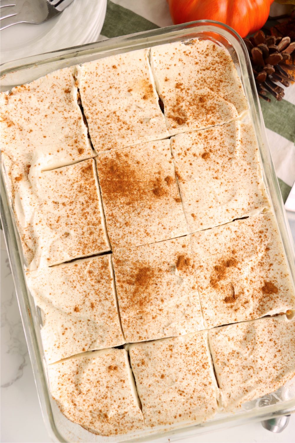 glass pan of sliced pumpkin poke cake