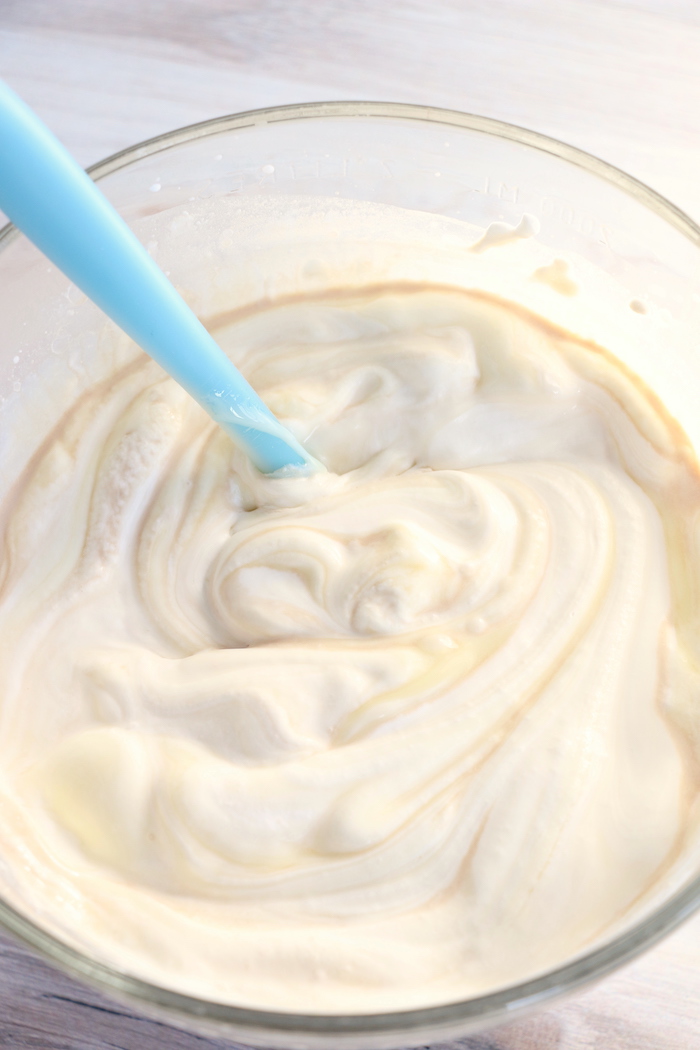 Stirring a mixture of whipped cream, vanilla and sweetened condensed milk
