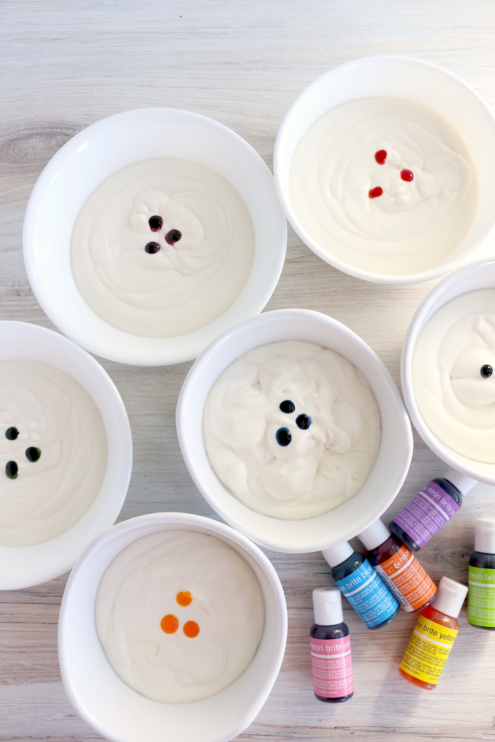 Homemade ice cream in containers with drops of food coloring