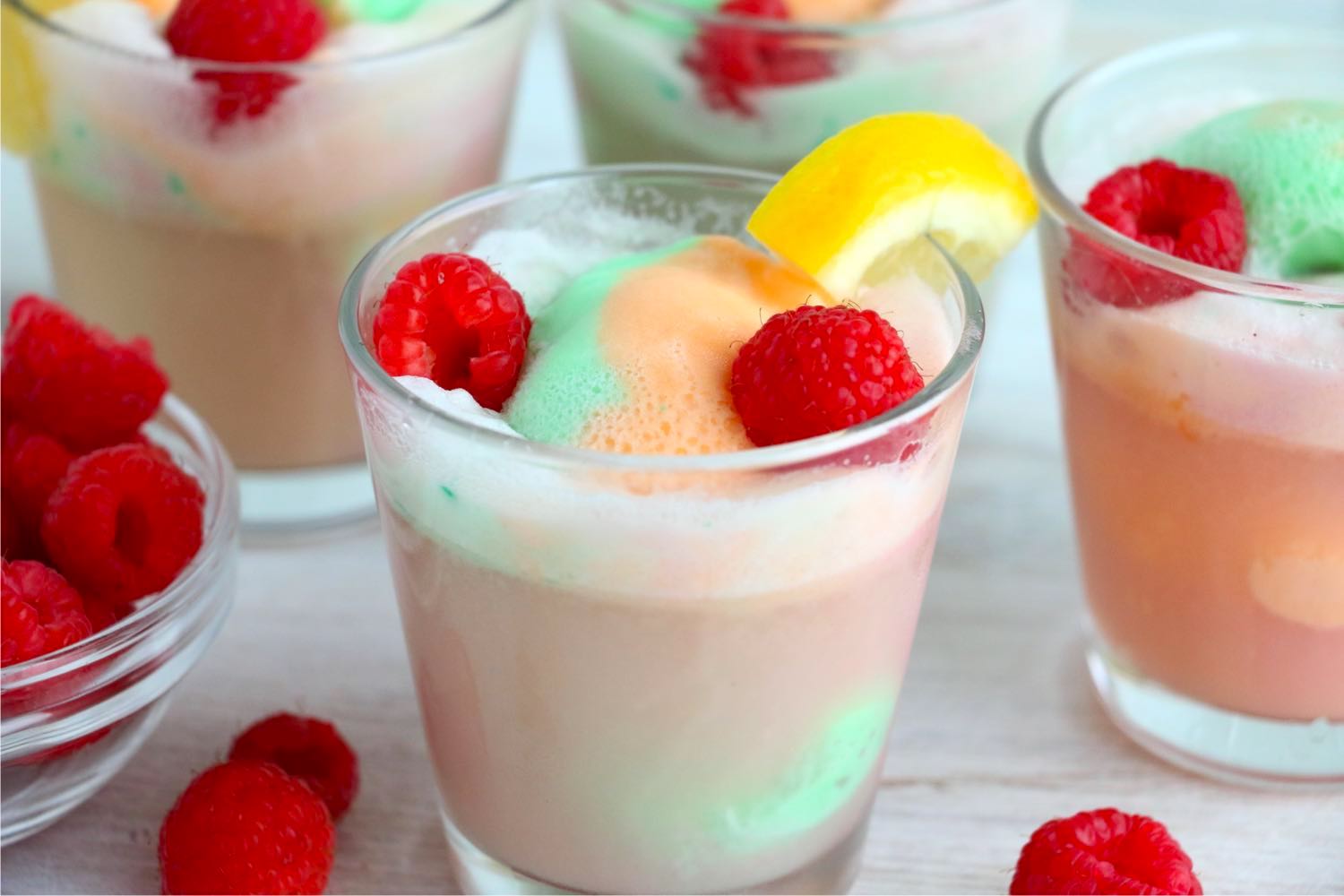 Sherbet punch in glasses with raspberries and lemon slices