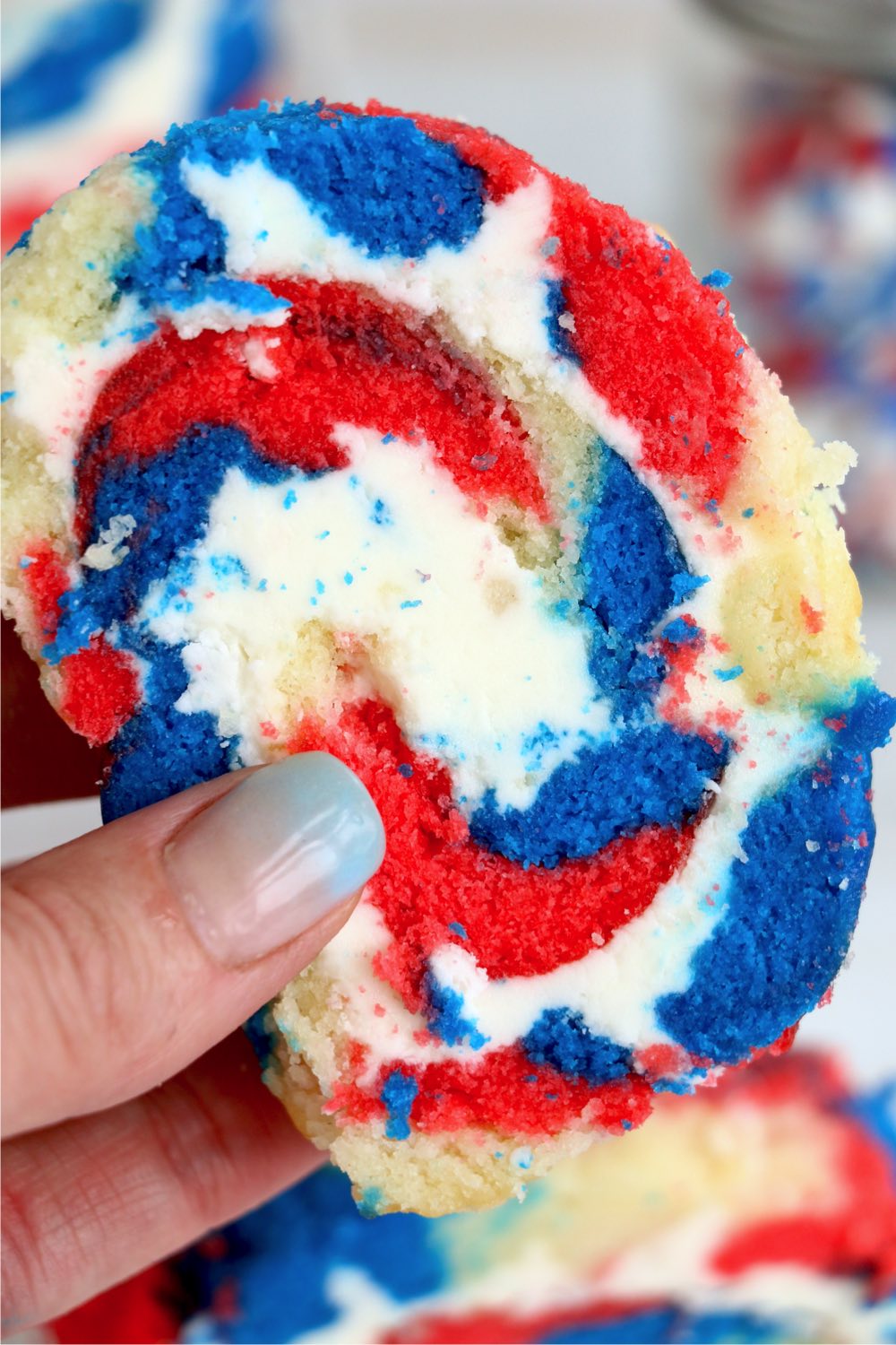 hand holding cake roll with frosting