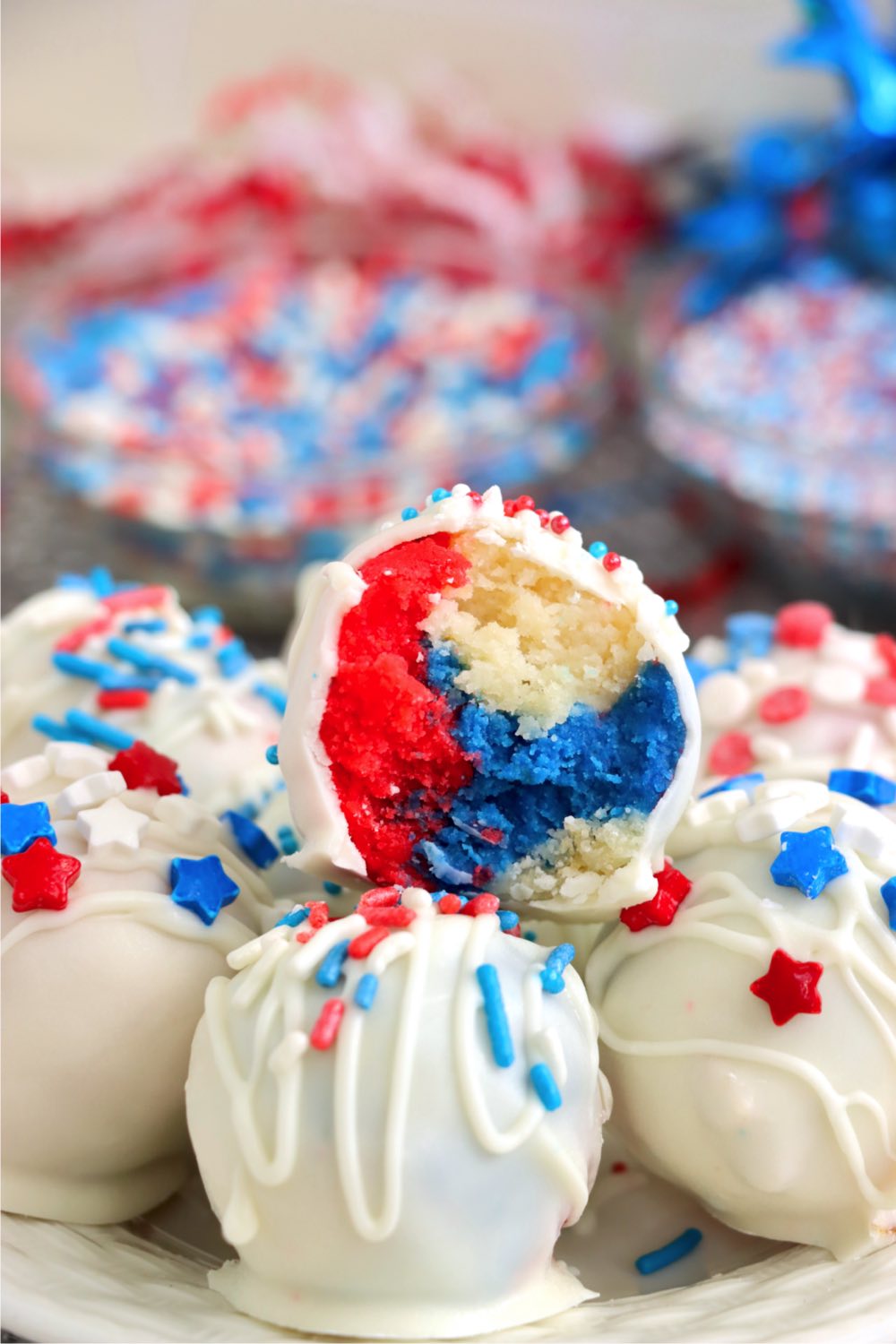 A half-eaten, red, white and blue truffle on top of a stack of more truffles.