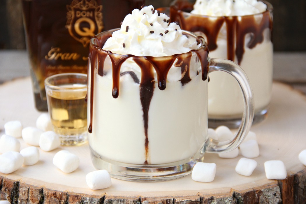 Rum & White Chocolate Hot Cocoa - a heavenly combination of white chocolate, rum, marshmallows, drizzles of chocolate and a big swirl of whipped cream topped with sprinkles is the ultimate fall indulgence!