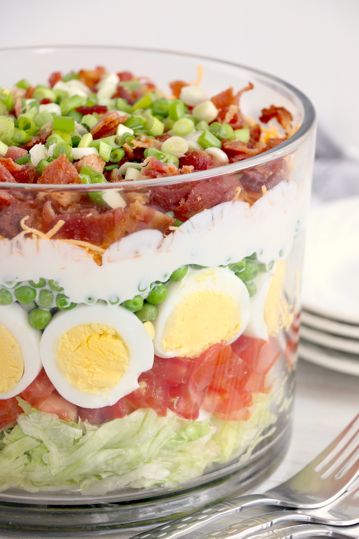 side shot of seven layer salad in trifle bowl