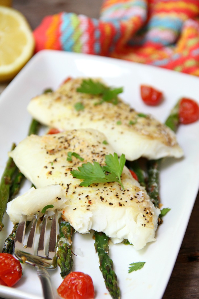 Sheet Pan Cod - A simple one-sheet recipe that features light, flaky cod alongside colorful asparagus and tomatoes. Lemon pepper, fresh lemon juice and grated Parmesan cheese top off the dish.