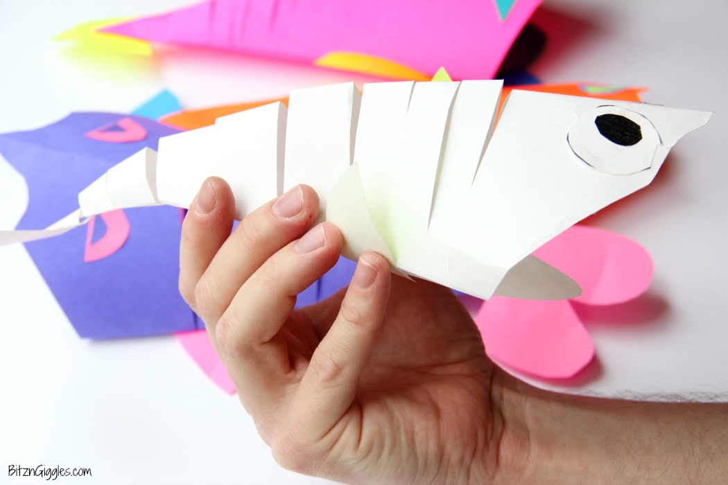 Slinky Fish Craft - All you need is construction paper, scissors and glue stick for this fun and colorful kids craft! The slinky "cut" makes the fish flexible almost like it's swimming!