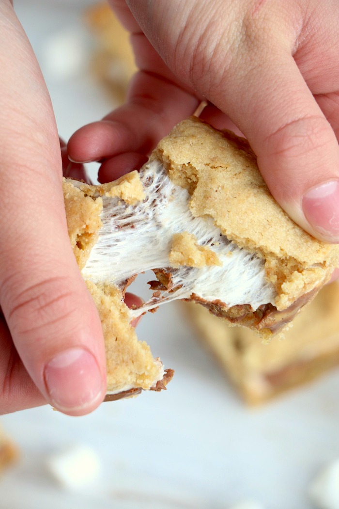 pulling apart a dessert bar filled with marshmallow