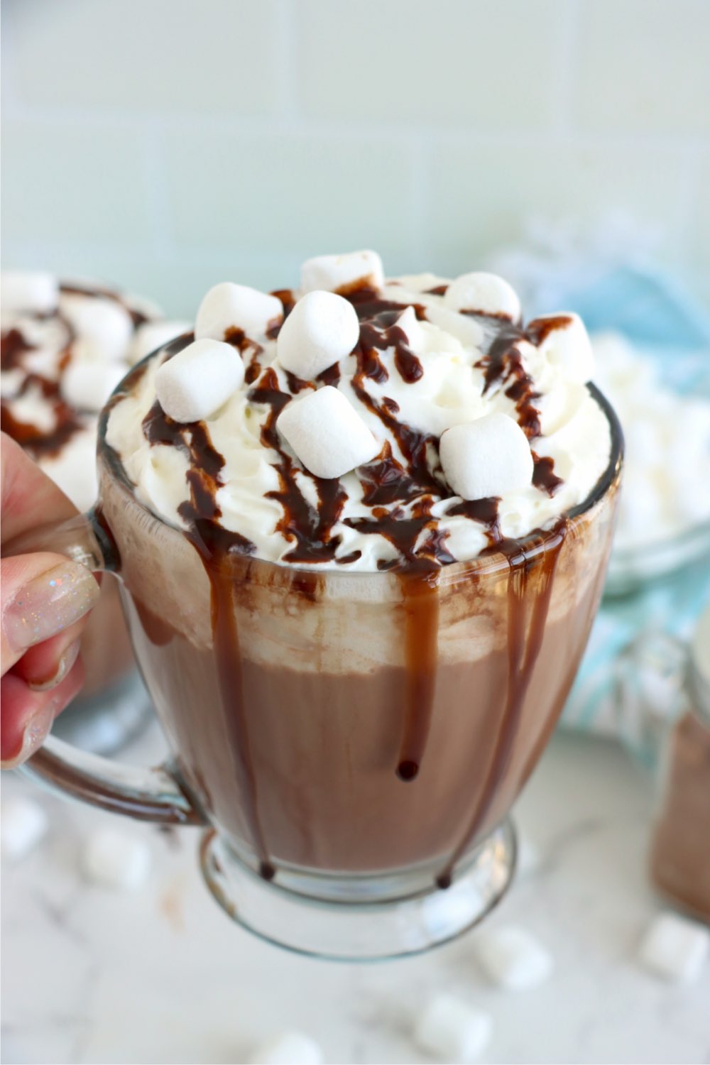 hand holding glass mug with toppings