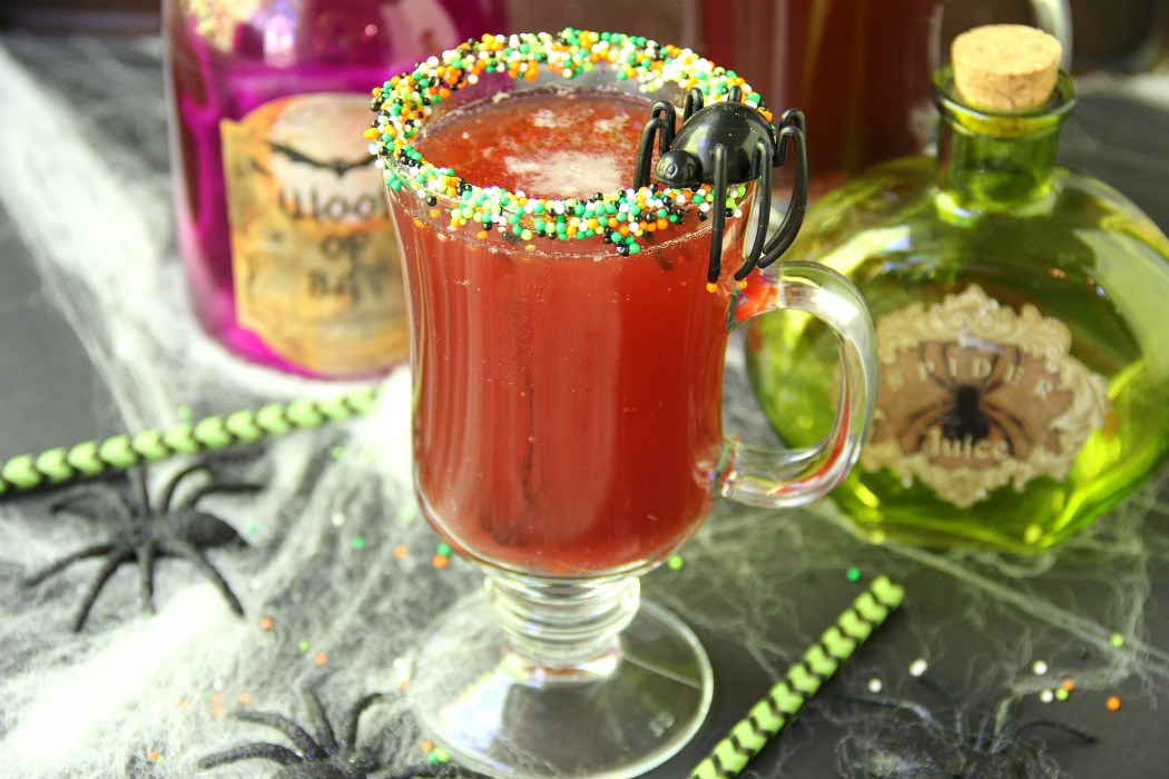 Spooky Halloween Punch - This Halloween punch is only three ingredients! When served in a nonpareil-rimmed glass, the color of the candy starts dripping eerily into the punch, creating fun black streaks and darkening the color of the drink!