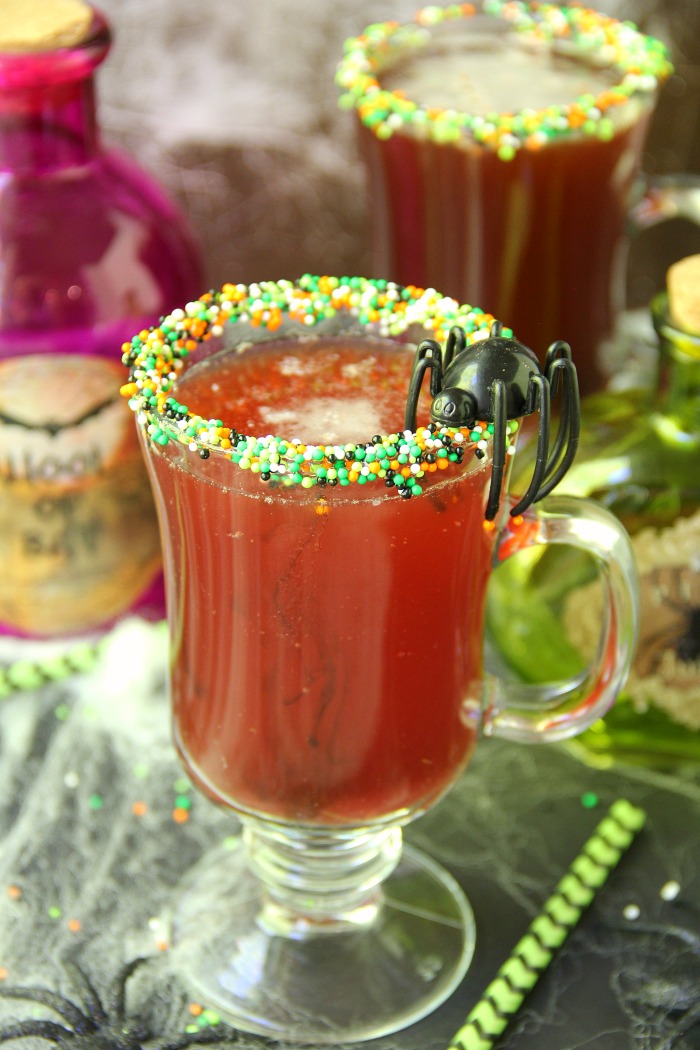 Spooky Halloween Punch - This Halloween punch is only three ingredients! When served in a nonpareil-rimmed glass, the color of the candy starts dripping eerily into the punch, creating fun black streaks and darkening the color of the drink!