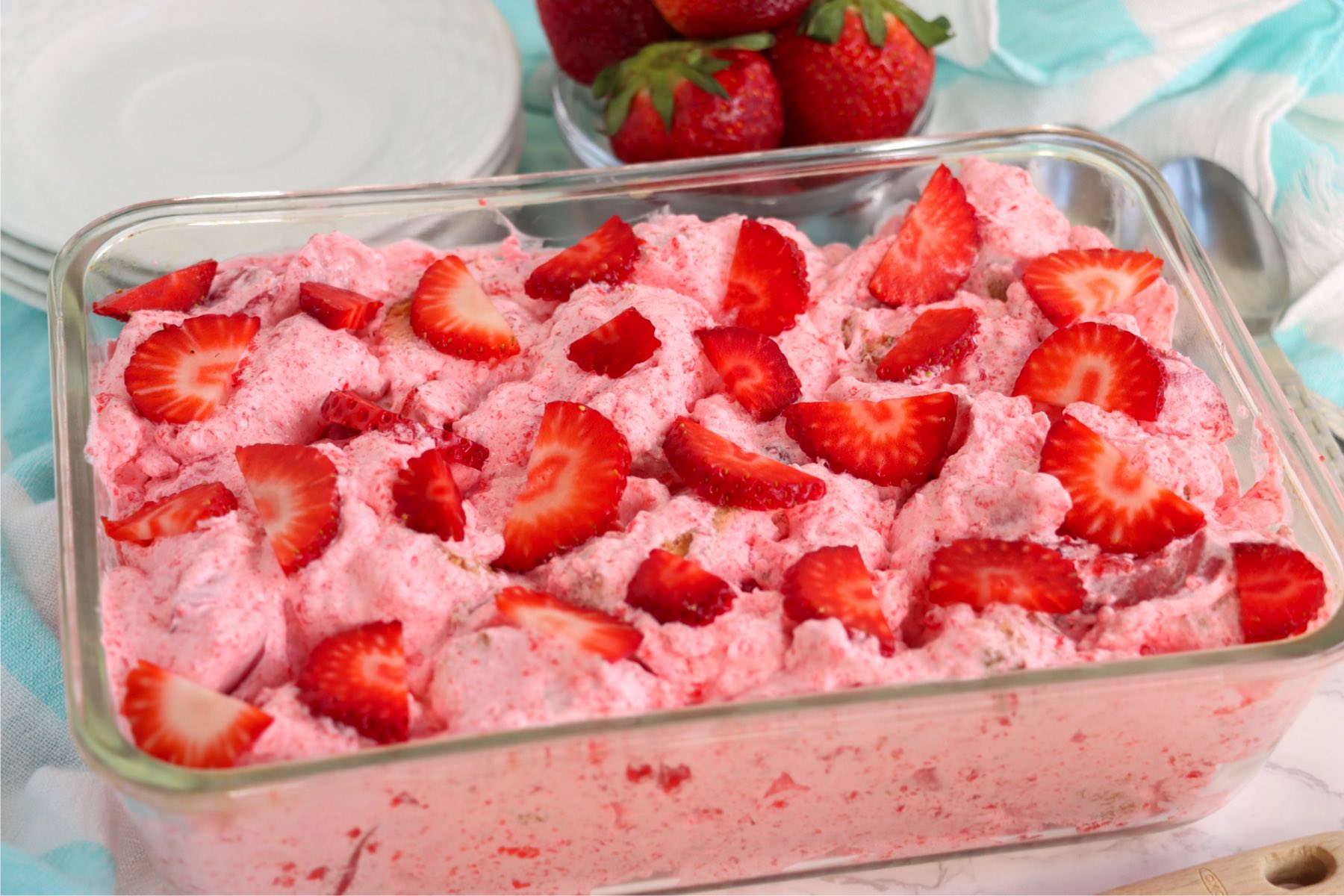 glass baking pan filled with a strawberry fluff dessert