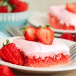 white dessert plate holding a strawberry brownie topped with fresh strawberries