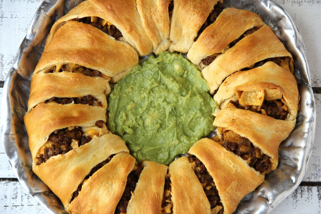 Ultimate Crescent Roll Taco Ring - This isn't just a taco ring, it's filled with guacamole, sour cream, cheese and tomatoes - easy and delicious, ready to serve a crowd!