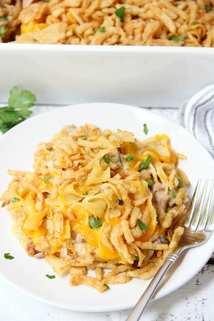 Classic Tuna Noodle Casserole - Ready in under 45 minutes, this classic and comforting casserole features tuna, onions, mushrooms, peas and cheese in a creamy sauce topped with more cheese and crunchy French fried onions! So flavorful, and sure to satisfy the entire family!