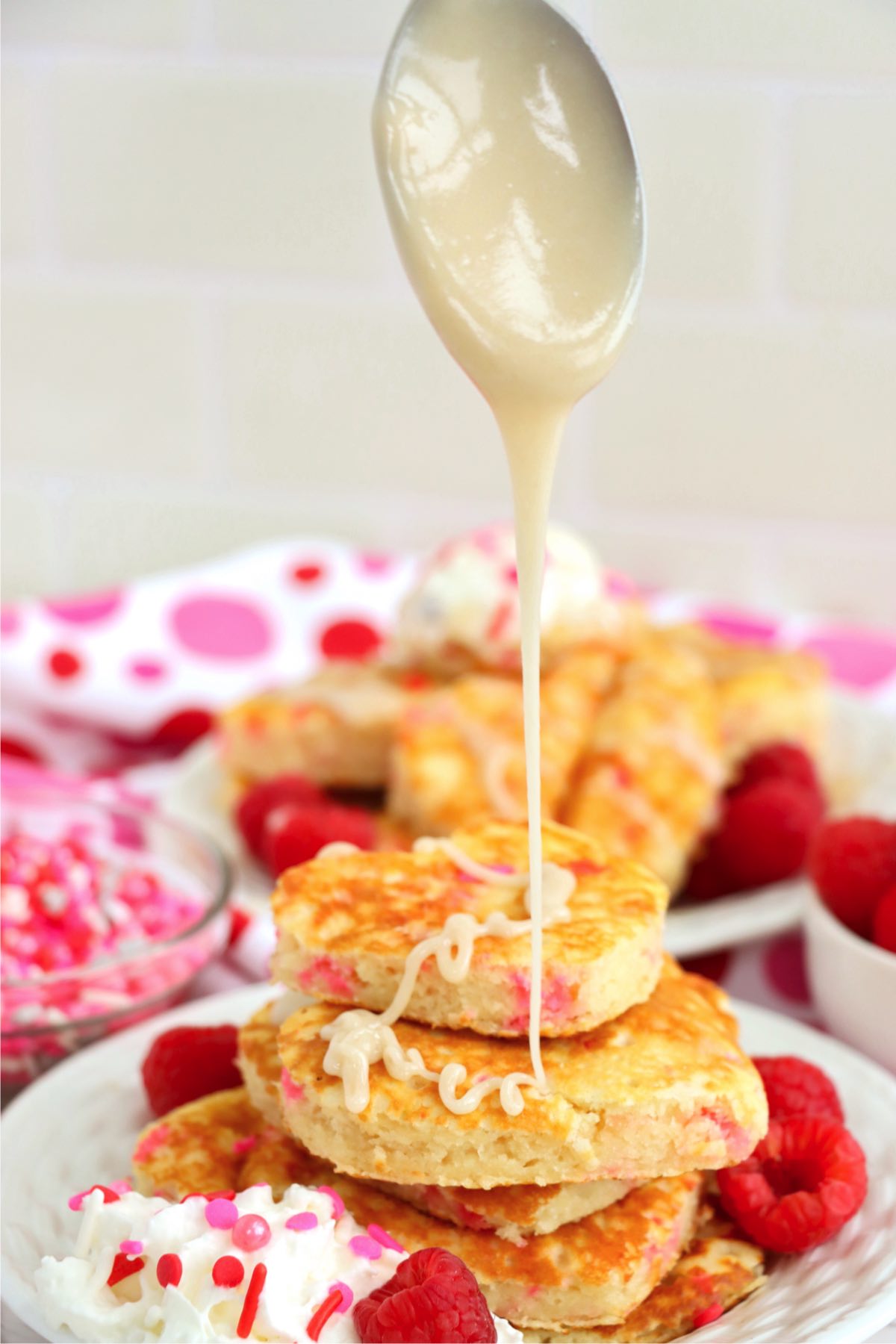 drizzling a stack of heart-shaped pancakes with glaze