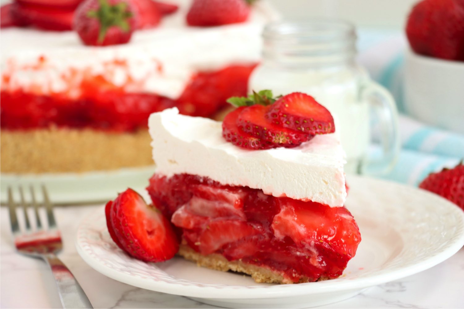 piece of frosted strawberry pie with fresh berries on top