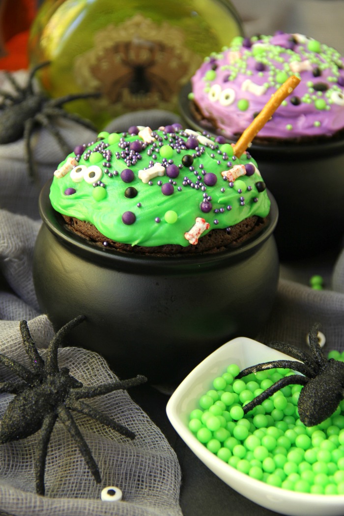 Witch Cauldron Mug Cake - A chocolate mug cake made in a ceramic witch cauldron with halloween-themed frosting and sprinkles!