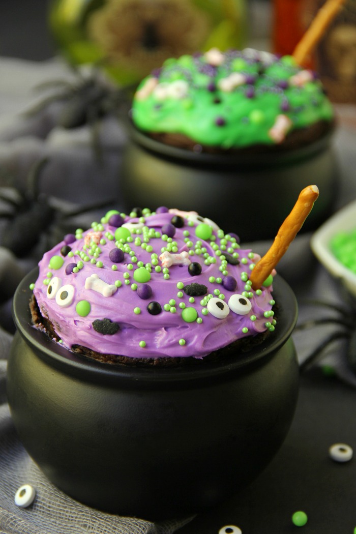 Witch Cauldron Mug Cake - A chocolate mug cake made in a ceramic witch cauldron with halloween-themed frosting and sprinkles!