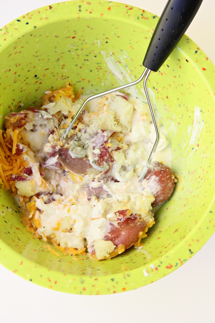 Twice Baked Potato Bowl - Baby reds are steamed, mashed, loaded with delicious toppings and then drizzled with a cheesy broccoli sauce. Tastes just like a twice baked potato but prepared in record time!